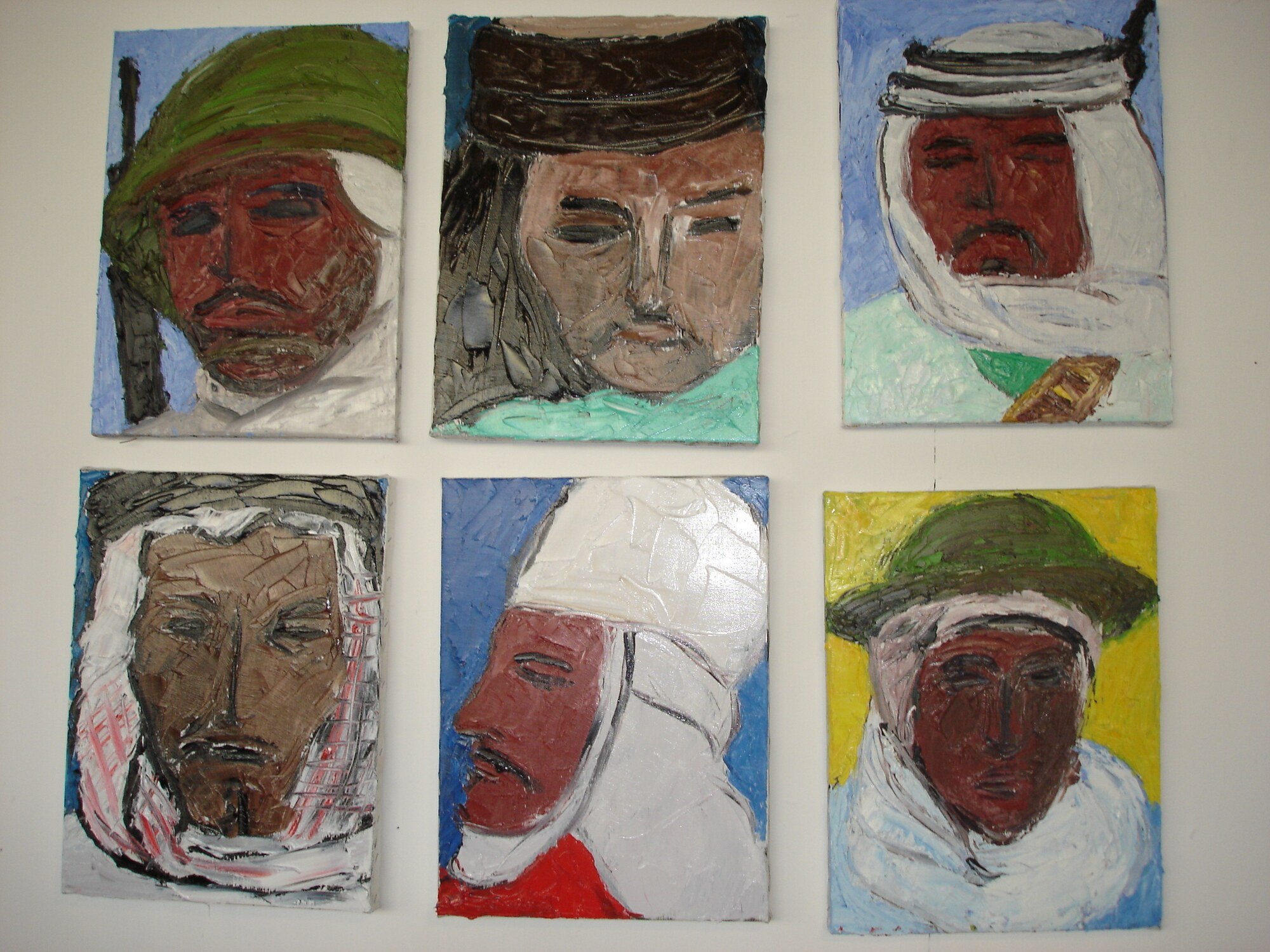 Six petits portraits de combattants au casque ou au keffieh, fonds bleu, jaune et turquoise, accroches sur un mur blanc, Marc Sardina