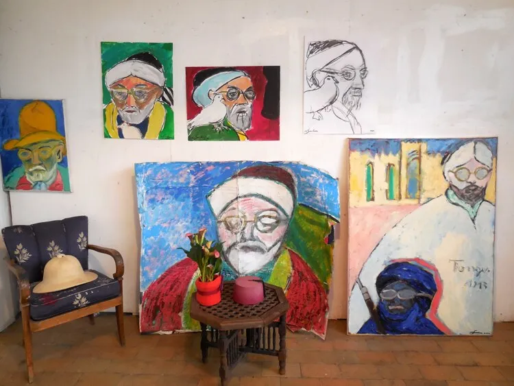 Mur d'atelier aux portraits de Matisse avec colombes, vert, rouge et bleu, fauteuil et table octogonale, installation de Marc Sardina