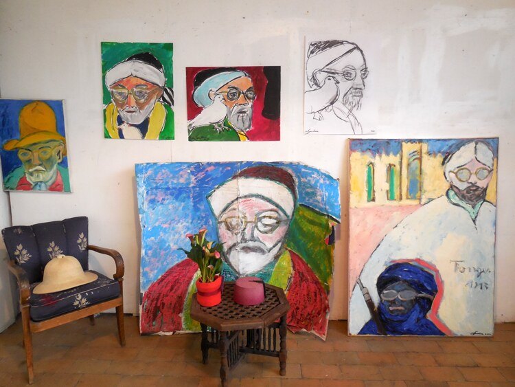 Mur d'atelier aux portraits de Matisse avec colombes, vert, rouge et bleu, fauteuil et table octogonale, installation de Marc Sardina